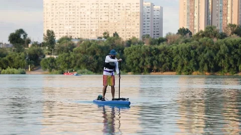 Man ride on SUP board in the mountain lake Stock Footage 204087642