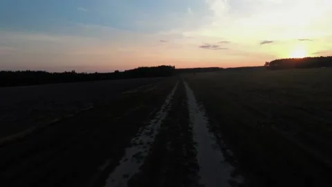 A man rides an ATV on a field at sunset, a camera on his helmet Stock Footage 172089284
