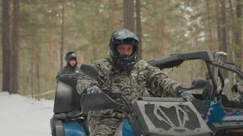 Man Rides ATV Through Forest. Cold Winter Journey on AllTerrain Vehicle. Man Stock Footage 332167060