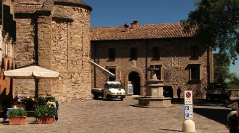 Man rides bicycle at the central square of the medieval town of San Leo, Italy. Stock-Footage 60092896