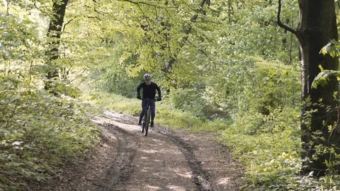 Man Rides Bicycle in the Forest 動画素材 75563355