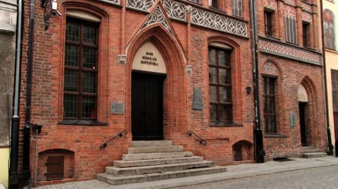 Man rides bicycle in front of the Copernicus house in Torun, Poland. Video stock 58631555
