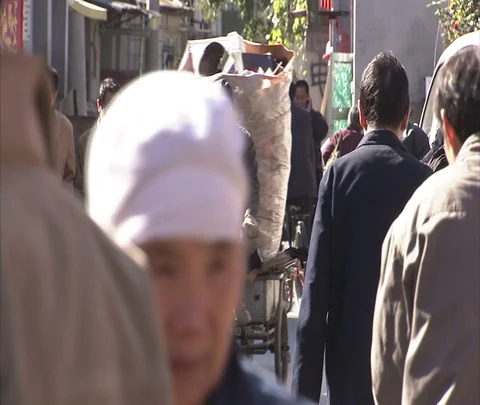 Man rides bicycle with huge bundle of trash through pedestrians Stock Footage 86745235