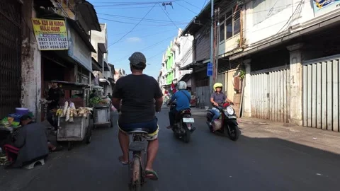Man rides bicycle through busy street 库存影片 345154533