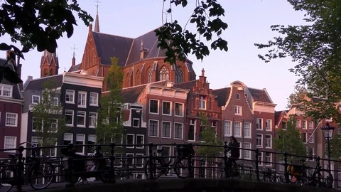 A man rides bicycle while talks on the smartphone, seeing streets, canals Stockbeeldmateriaal 77603324