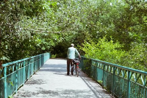 A man rides a bridge on a bicycle Stock Photos