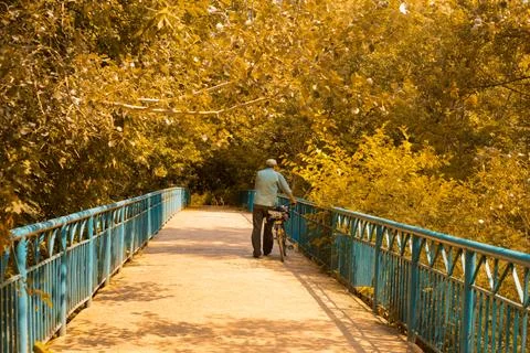 A man rides a bridge on a bicycle Stock Photos