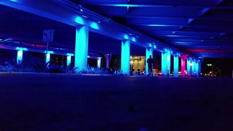 Man Rides Electric Scooter Under Colorful Bridge, Far, San Antonio Stock Footage 146554543