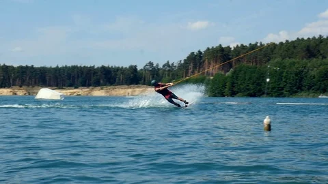 A Man Rides His Wakeboard At A Cable Park, Slow Motion. wake boarding tricks. Video stock 97041817