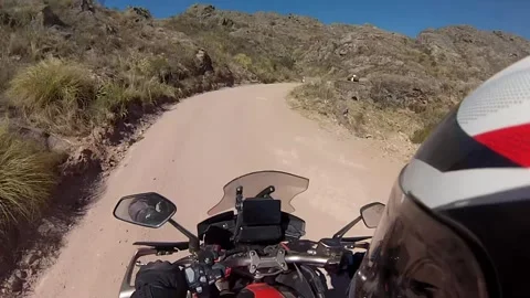 A man rides a motorcycle through the off road in a hills Stock Footage 253318086