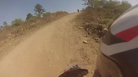 A man rides a motorcycle through the off road in a hills Stock Footage 253318097