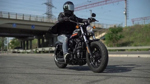 Man rides a motorcycle under a bridge Stock Footage 129105029