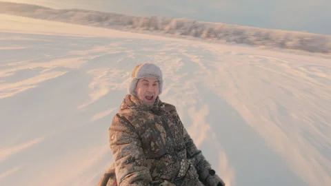 A man rides from a rolling snow slide on a round inflatable sleigh. Stock Footage 325860304