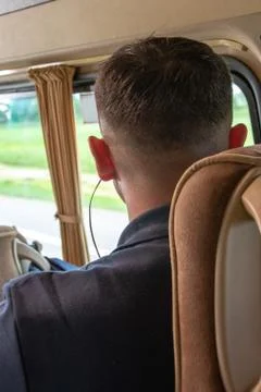 A man rides in a Shuttle bus and listening to music in headphones Foto stock
