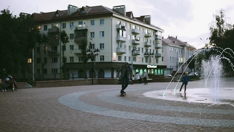 Man rides a skateboard near the fountain Stock Footage