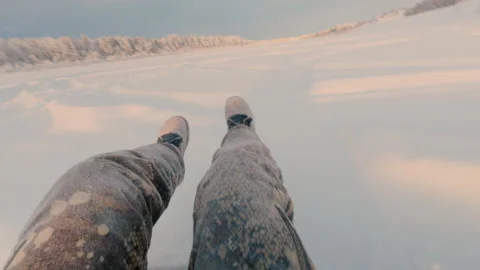 A man rides a sleigh down a high hill in winter. A snow tubing run. Stock Footage 325860154