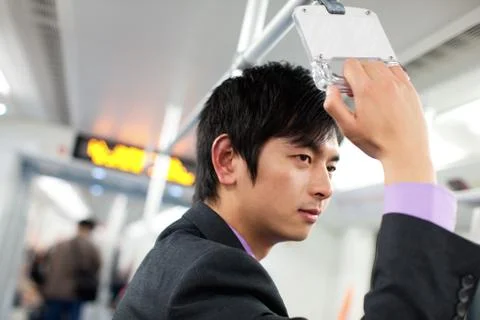 A man rides a subway while commuting to and from work Stock Photos