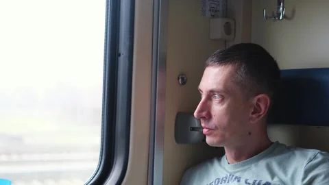 A man rides a train and looks out the window Stock Footage 272744933