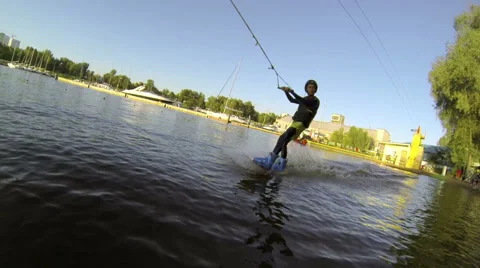 A man rides a wakeboard next to the camera on the lake. Slow motion. Stock Footage 56199074