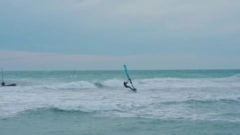 Man rides on the waves on a windsurfing board Stock Footage 160541537