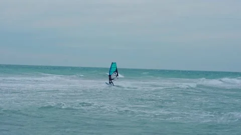 Man rides on the waves on a windsurfing board Stock Footage 160541648