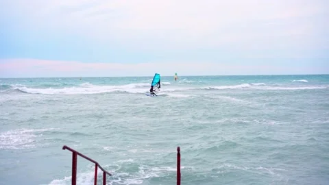 Man rides on the waves on a windsurfing board Stock Footage 160541831
