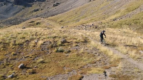 Man is riding around the field in high mountains. Stock Footage 83735361