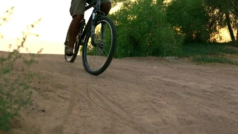Man riding a bicycle down the slope in slow motion at sunset Video stock 81231485