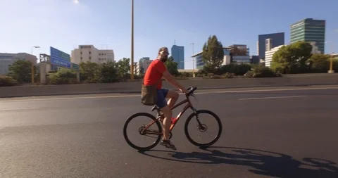 Man riding bicycle in the middle of empty Ayalon highway. Tel Aviv. DJI_0098-01 Stock-Footage 104501733