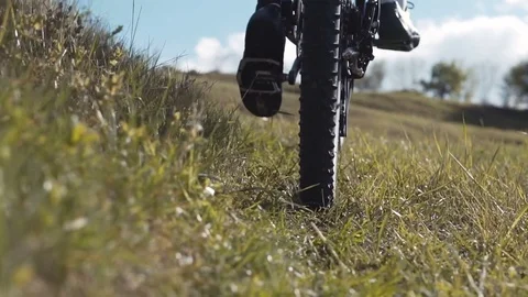 Man Riding Bicycle up Mountain Grass Hill 動画素材 75562073