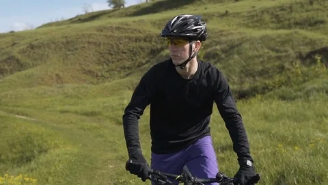 Man Riding Bicycle up Mountain Grass Hill 库存影片 75562552