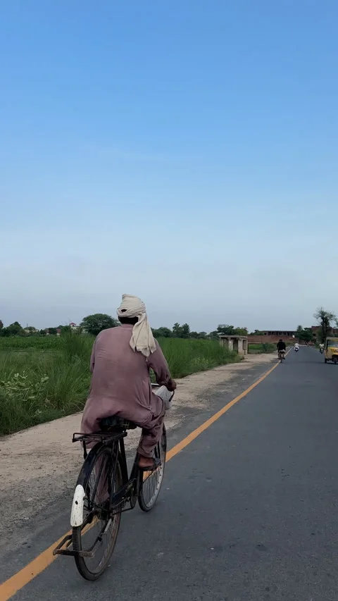 Man Riding Bicycle on Paved Rural Road 스톡 동영상 337137771