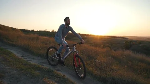 Man is riding a bicycle at sunset Stock Footage 80838202