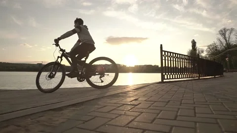 Man riding the bicycle on the sunset Stock Footage 130473016