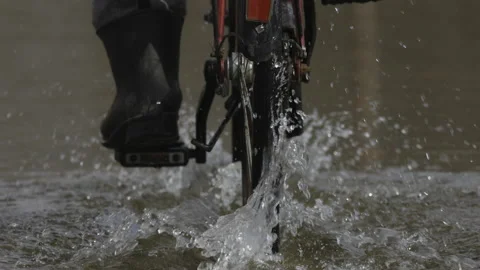 A man is riding a bicycle on the water, 4K slomo Stock Footage 237520706