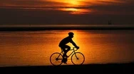 Man Riding Bike By Ocean At Sunset Cinemagraph Stock Footage
