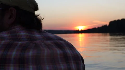 A man riding a boat on the river on a summer evening against the background of a Stock-Footage 283491610