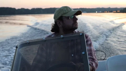 A man riding a boat on the river on a summer evening against the background of a 動画素材 283530610