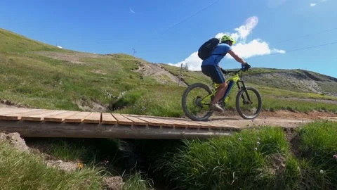 Man riding electric mountain bike on top of mountain in summer sunny day Stock Footage