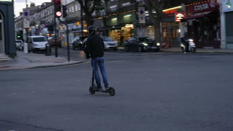 Man riding an electric step on the road in the evening. London, United Kingdom. Stock Footage 218805249
