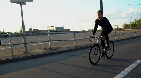Man riding fixed gear bike on the road at sunset Video stock 63201580