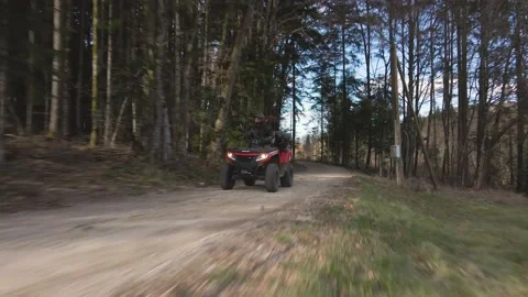 A man riding his quad bike - ATV through the woods on a sunny day - 4k footage Stock Footage