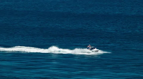 Man Riding Jet Ski on Blue Ocean Water Stock Footage 61006743