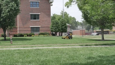 A man riding a lawnmower 스톡 동영상 75619585