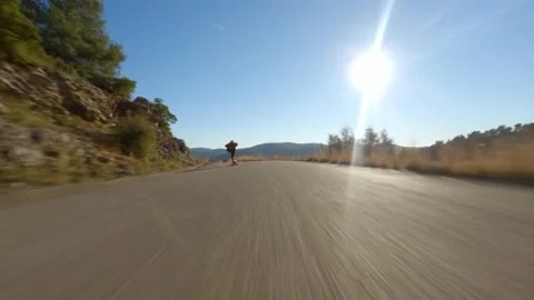 Man riding a longboard on sunset in a road. Skateboard travel. Longboarding. Stock Footage 168190073