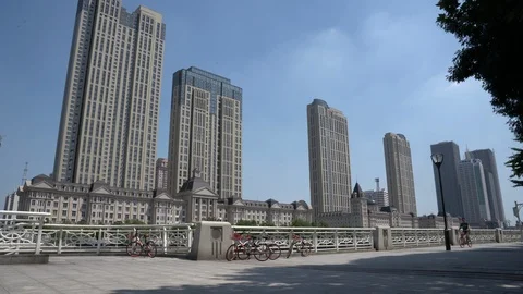 A man riding a Mobike's shared bike along Haihe River in downtown Tianjin Stock Footage 94170993