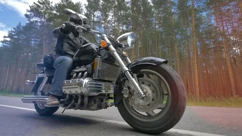 A man riding a motorcycle with its front wheel in close view. 4K. Stock Footage