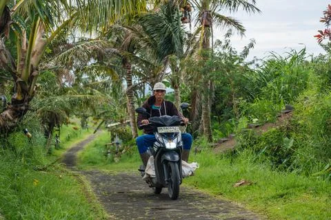 Man Riding Motorcycle on a Tropical Path Stock-Fotos