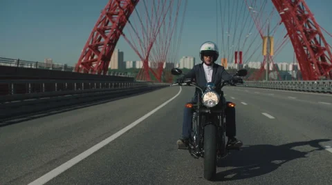 Man riding a motorcycle under the bridge in a city Stock Footage 63456436