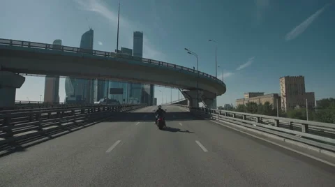 Man riding a motorcycle under the bridge in a city Stock Footage 63458669